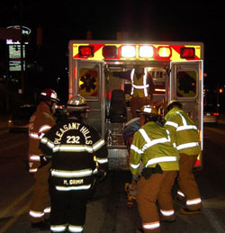 EMTs load a patient into their ambulance.